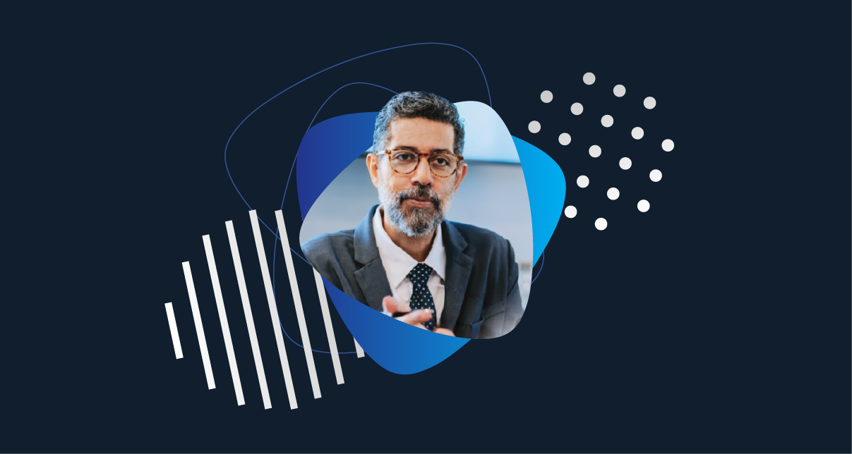 business executive in a suit looking directly at the camera, framed by abstract blue graphics on a dark background